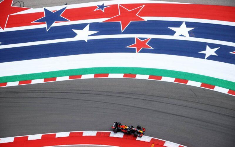 a red white and blue race car driving down a track