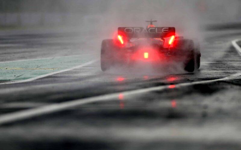 a red race car driving on a wet track