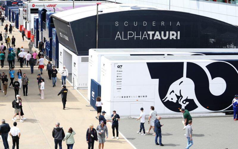 a crowd of people walking around a paddock of f1