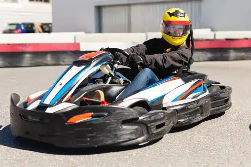 a man riding a go kart on top of a race track