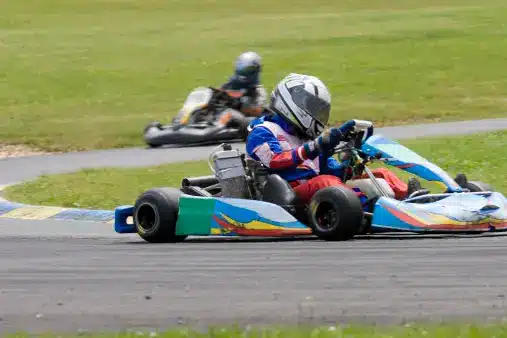 two people racing go kart cars on a track