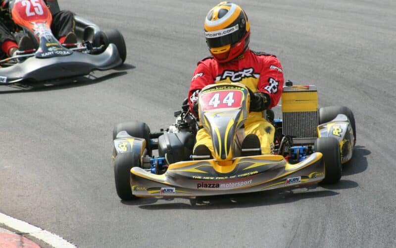 two people in go kart racing on a race track