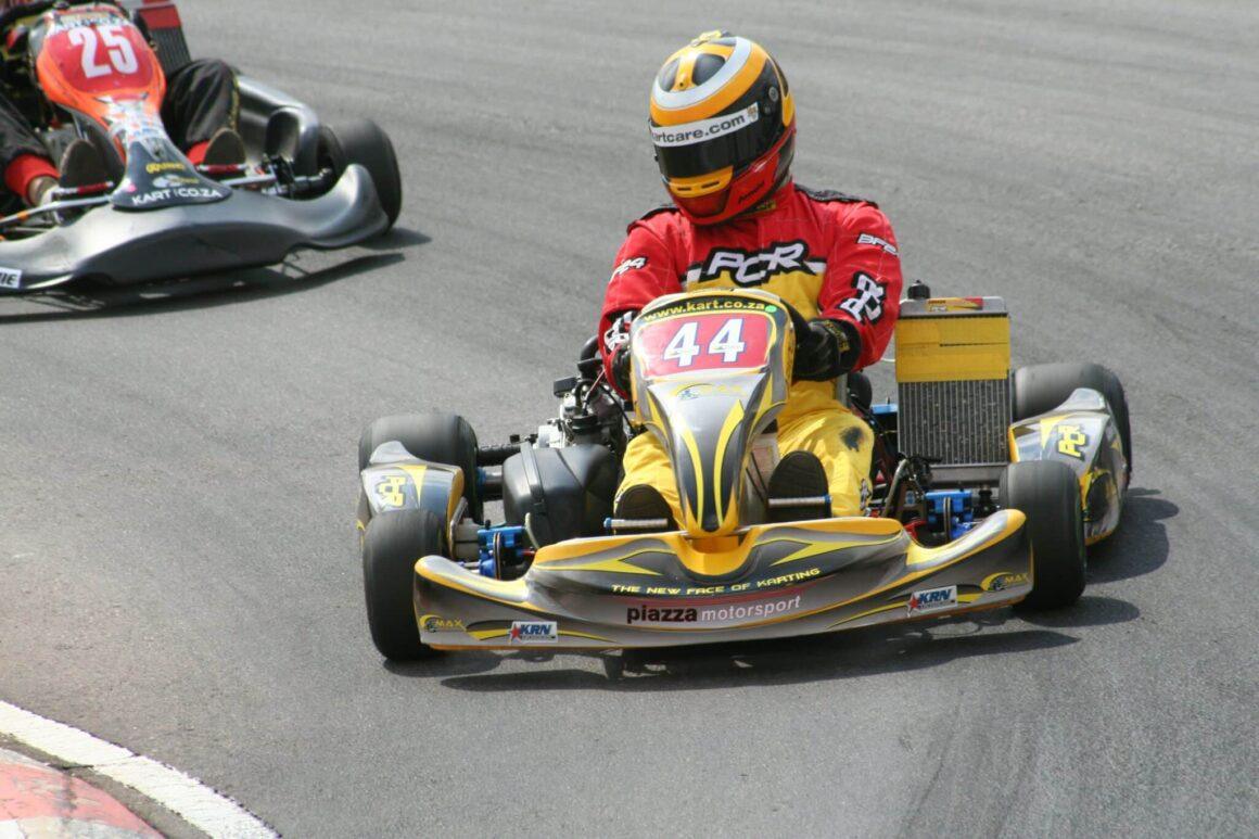 two people in go kart racing on a race track