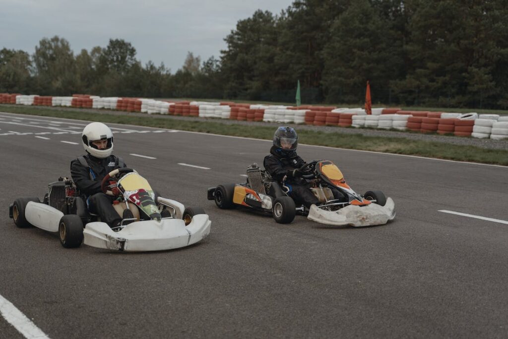 two people riding go karts on a race track