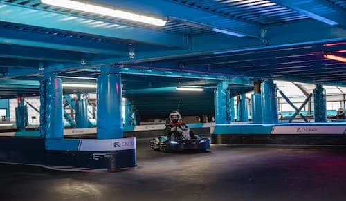 a person riding a go kart in a parking garage