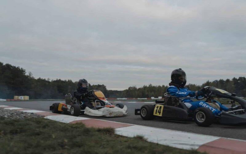 two people in go kart racing on a race track