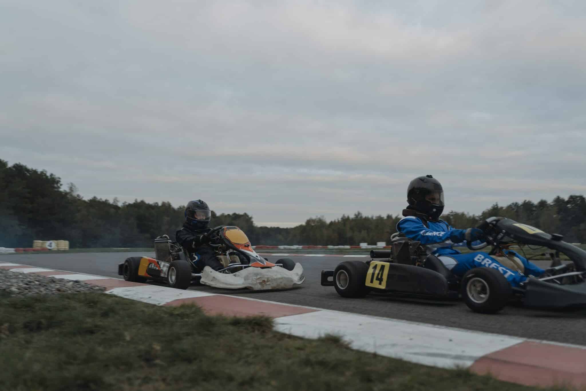 two people in go kart racing on a race track