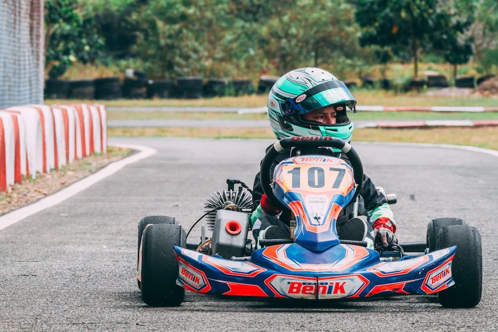 a person in a go kart racing car on a race track