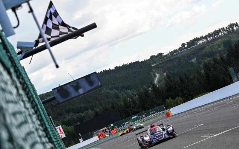 a group of cars driving down a race track