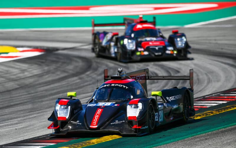 two racing cars racing on a race track