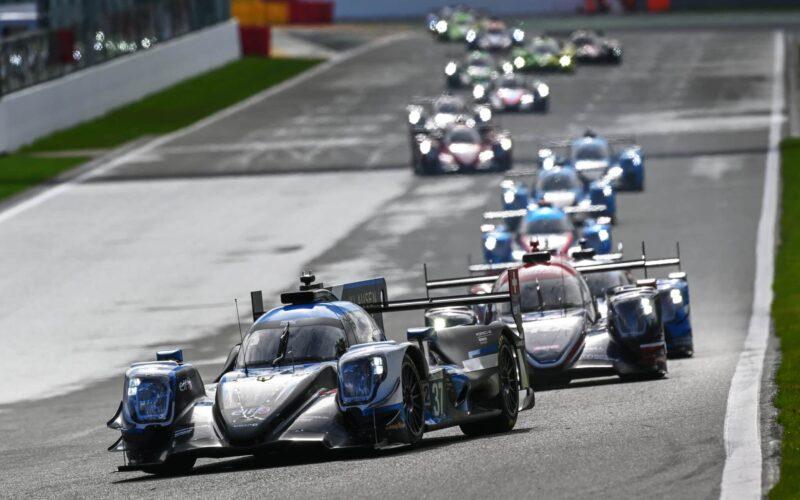 a group of racing cars driving down a race track