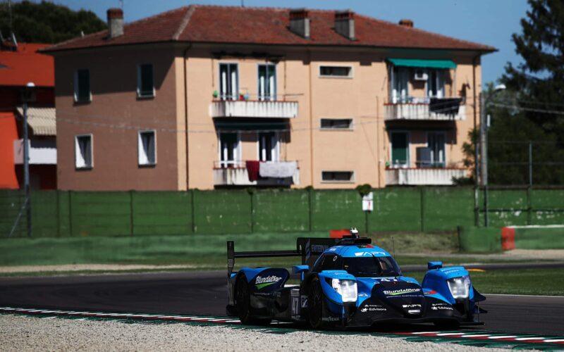 a blue race car driving down a race track
