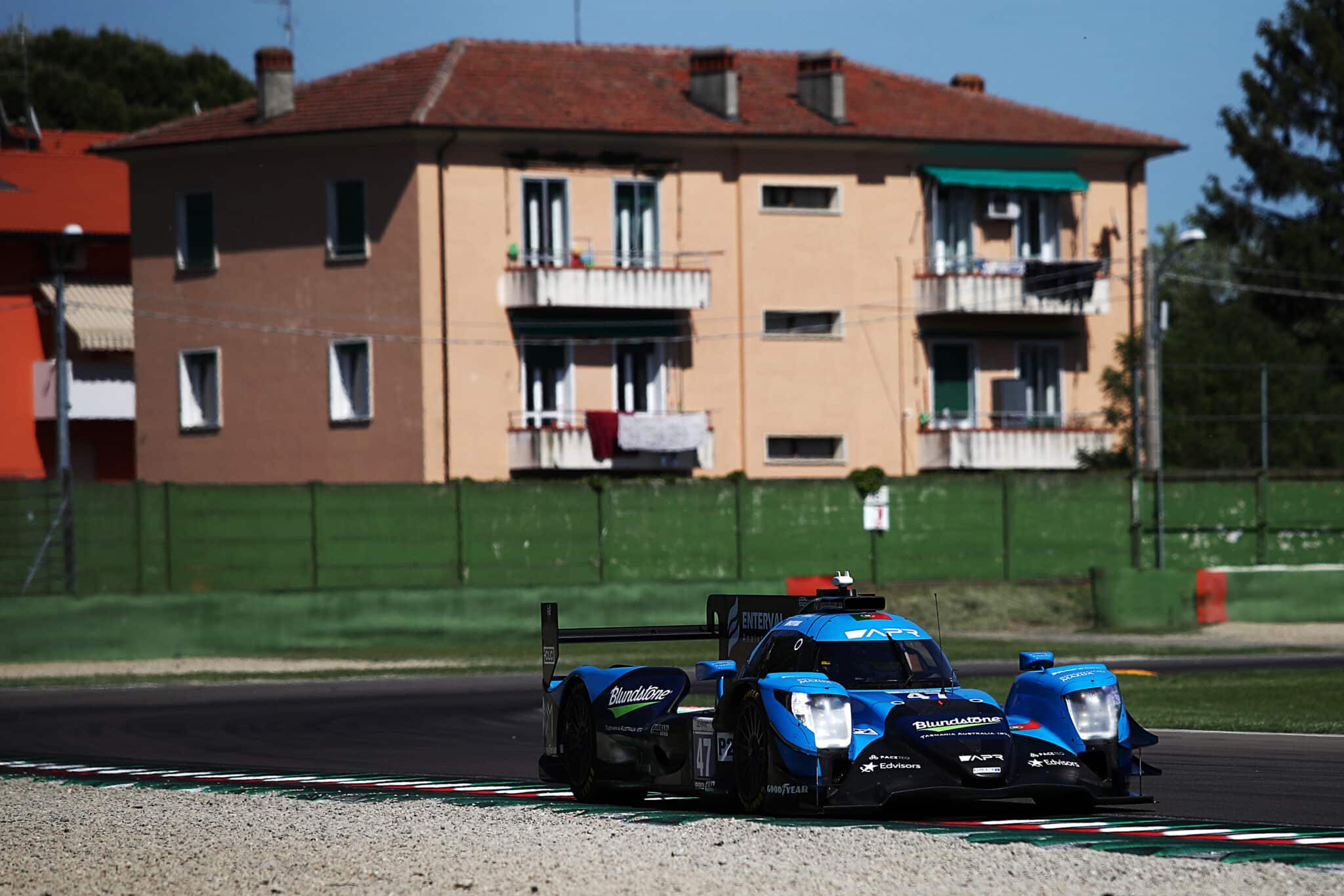 a blue race car driving down a race track