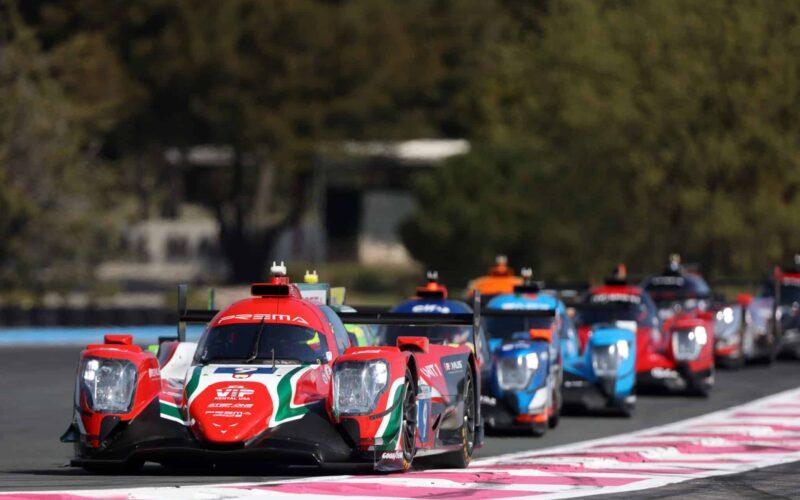 a group of cars driving down a race track