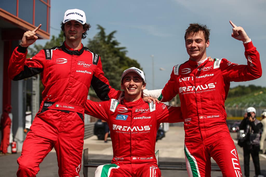 three men in red racing suits standing next to each other