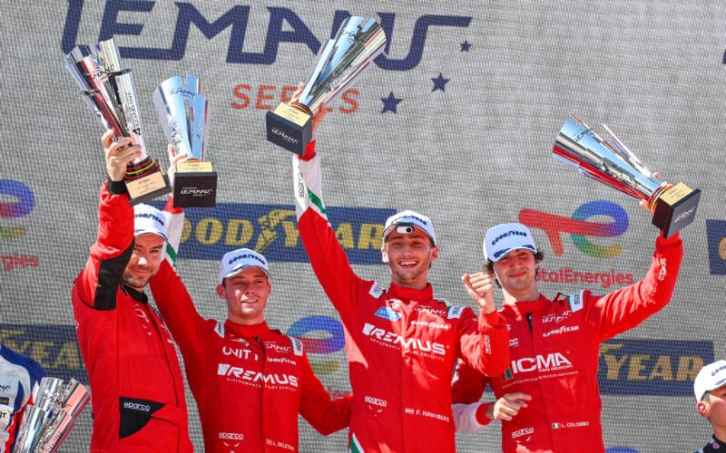 a group of men standing on top of a podium holding up trophies