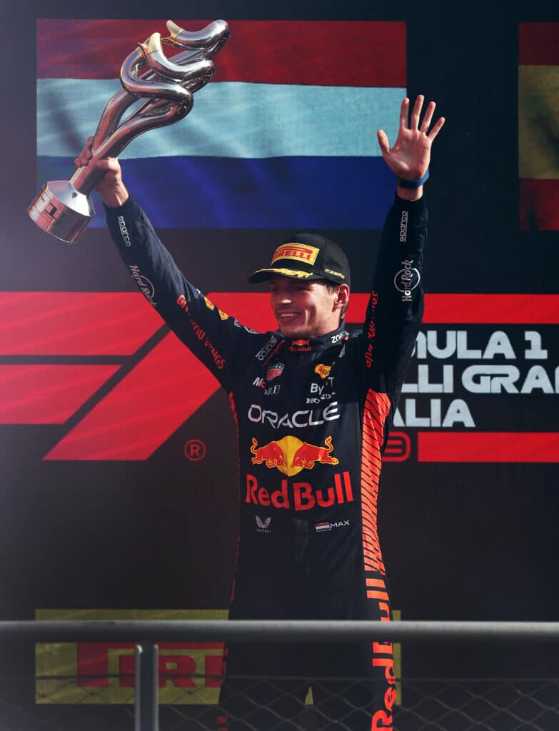 a man holding up a trophy on top of a podium