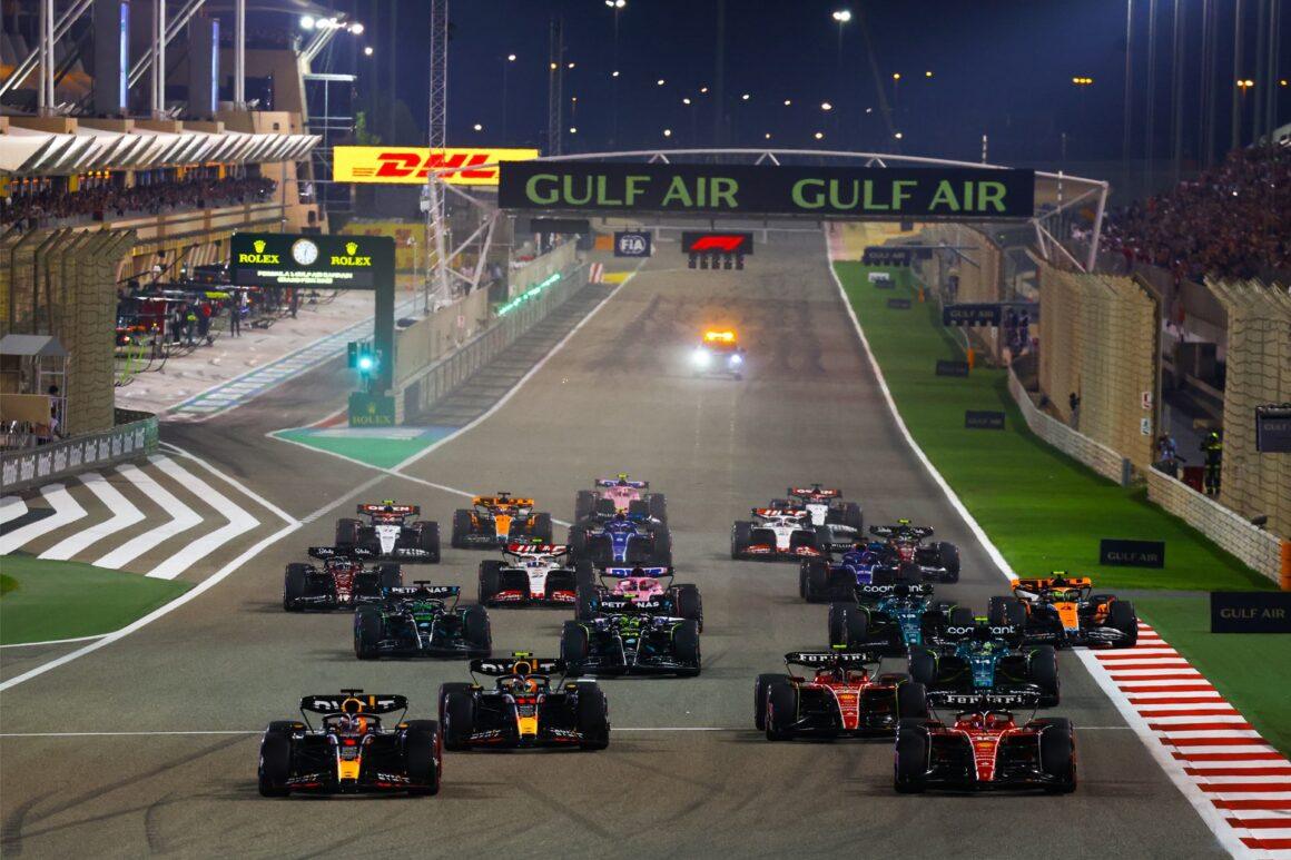 a group of cars driving down a race track