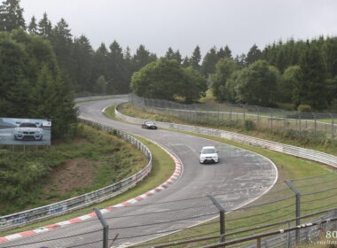 a car driving down a winding road near a forest