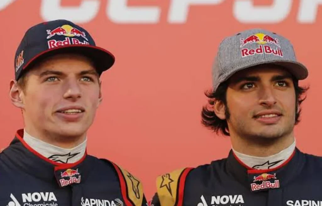 deux hommes debout l'un à côté de l'autre devant un panneau Red Bull