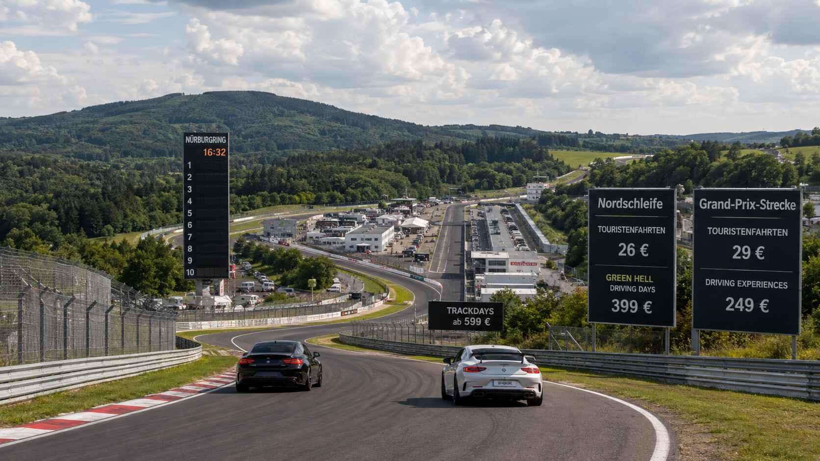 Deux Porsche sur circuit asphalté, encadrées par de grands panneaux noirs affichant les tarifs de la Nordschleife et du GP.